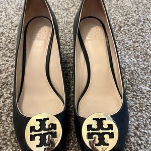 Black leather Tory Burch peep-toe wedges.
